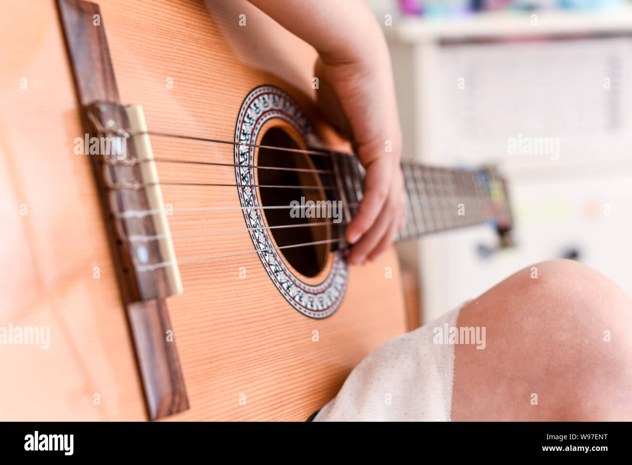 Mädchen lernt Gitarre während eine Musikstunde auf dem Instrument zu spielen Stockfoto