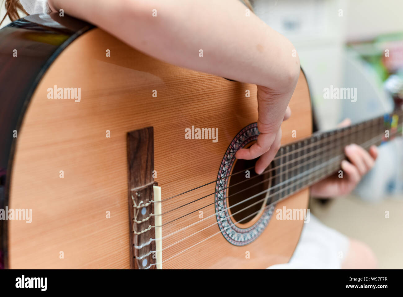 Mädchen lernt Gitarre während eine Musikstunde auf dem Instrument zu spielen Stockfoto