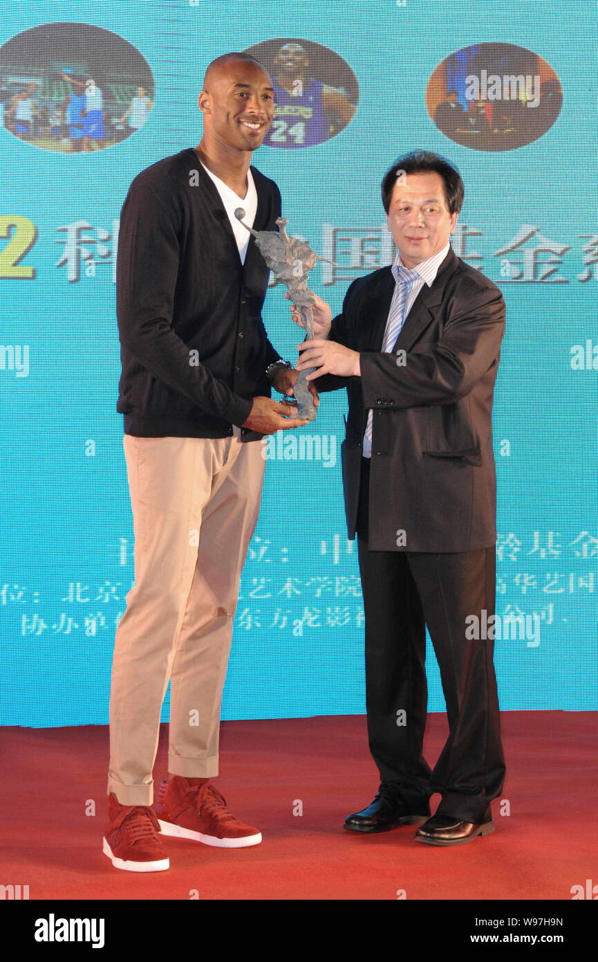 NBA Superstar Kobe Byrant, Links, erhält ein Geschenk von einem Gast während einer Nächstenliebe Bankett der Kobe Bryant China Fonds in Shanghai, China, 14. August 201 Stockfoto