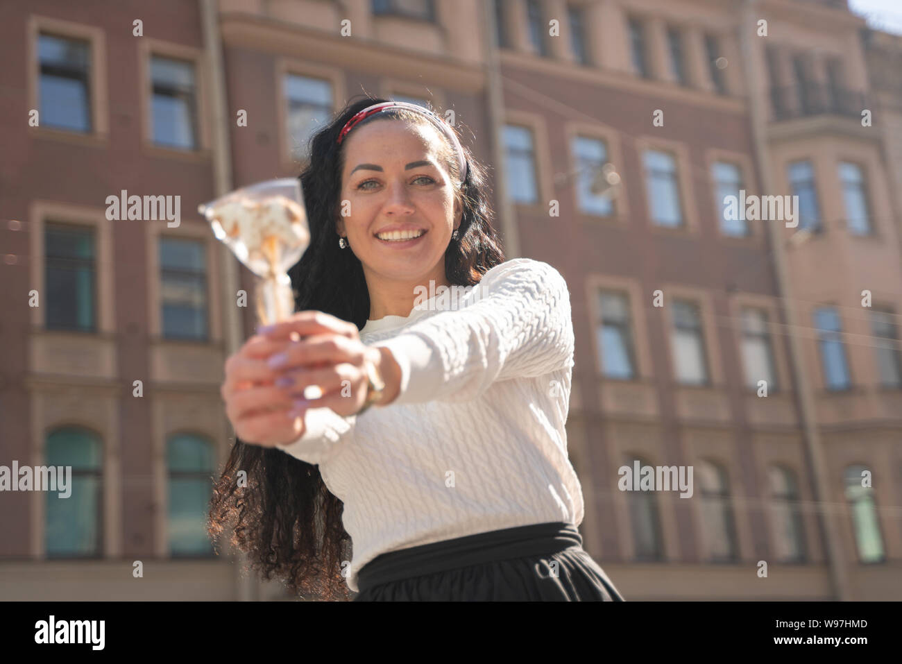 Recht glücklich kaukasische Frau zu Fuß in der Stadt mit Lollipop Stockfoto