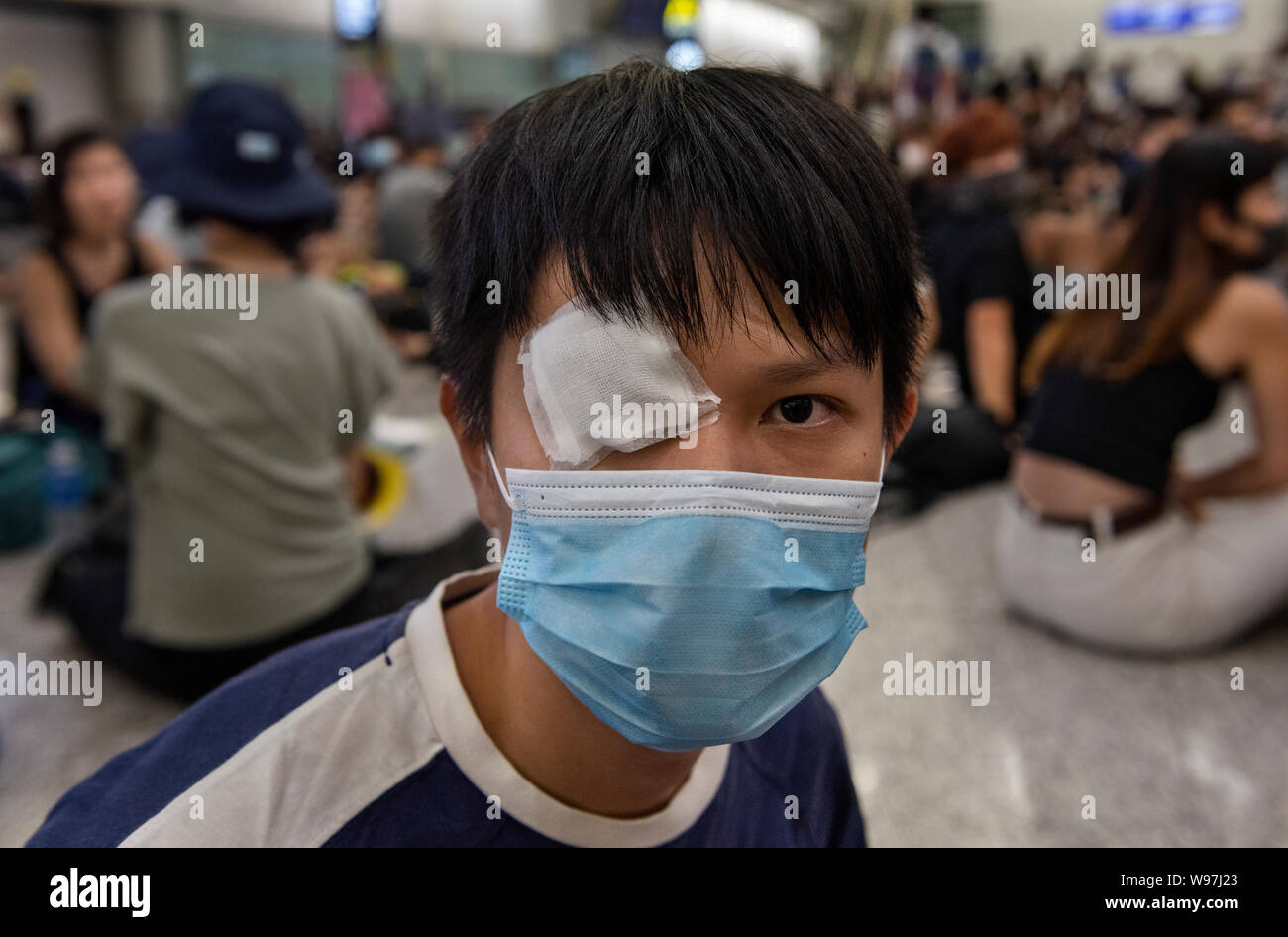 Porträt einer regierungsfeindlichen Demonstranten mit einer Augenklappe bei einem Sit-in demonstrant am Hong Kong International Airport. In Antwort vom Wochenende Gewalt, die eine Frau in die Augen, mit einem Projektil während der Auseinandersetzungen zwischen Demonstranten und der Polizei erschossen wurde, regierungsfeindlichen Demonstranten besetzten Hong Kong International Airport und zwang die Annullierung von Flügen. Stockfoto