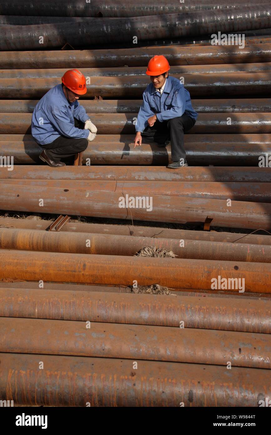 ------ Arbeiter gesehen prüfen Stahlrohre in einem Werk in Ostchina Huaibei, Provinz Anhui, 28. Juli 2011. Chinesische Rohstahlproduktion im September Stockfoto