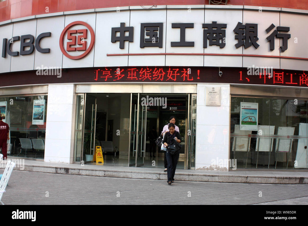 ------ Chinesische Frauen lassen ein Zweig der ICBC (Industrial & Commercial Bank of China) im Yunyang, Central China Chongqing, Provinz, 9. Oktober 2011. Stockfoto