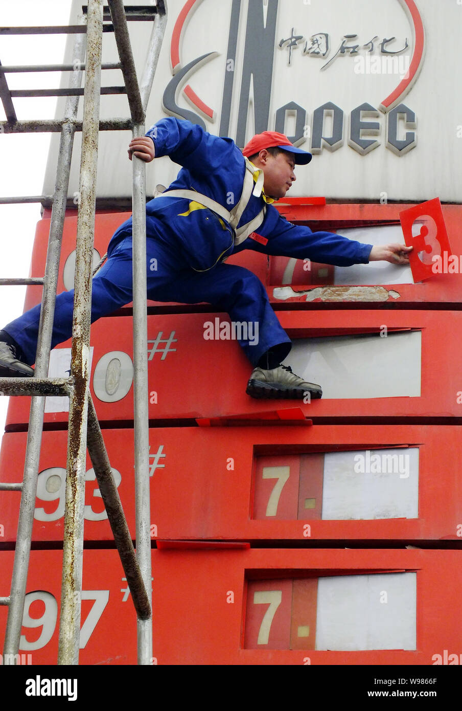 Ein chinesischer Arbeiter aktuelles Treibstoffpreise an einer Tankstelle von Sinopec in Kunshan City, Central China Provinz Hubei, 7. April 2011. China, Asias größte Stockfoto