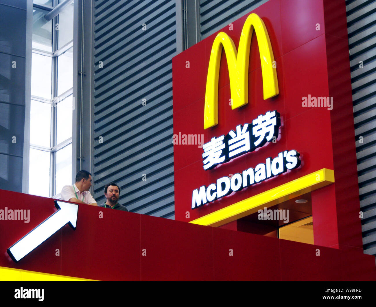 Zwei lokale Bewohner stehen vor einem McDonalds Restaurant in Shanghai, China, 23. Juni 2009. McDonalds sollen mindestens 700 neue Filialen in der zu öffnen. Stockfoto