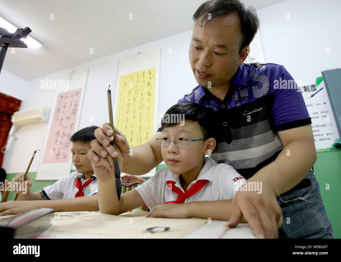 Ein Lehrer unterrichtet Kalligraphie in einer Klasse in Huaibei, East China Provinz Anhui, 29. August 2011. Kalligraphie, traditionelle Art und Weise der Aufnahme, ist die Künstlerin Stockfoto