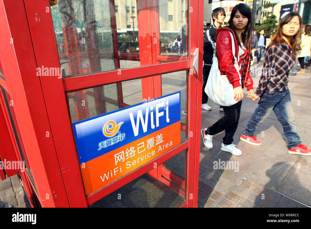 Lokale chinesische Bewohner vorbei an einer Telefonzelle von China Telecom bietet Wlan Dienstleistungen in der Innenstadt von Shanghai, China, 24. Februar 2011. Insgesamt o Stockfoto