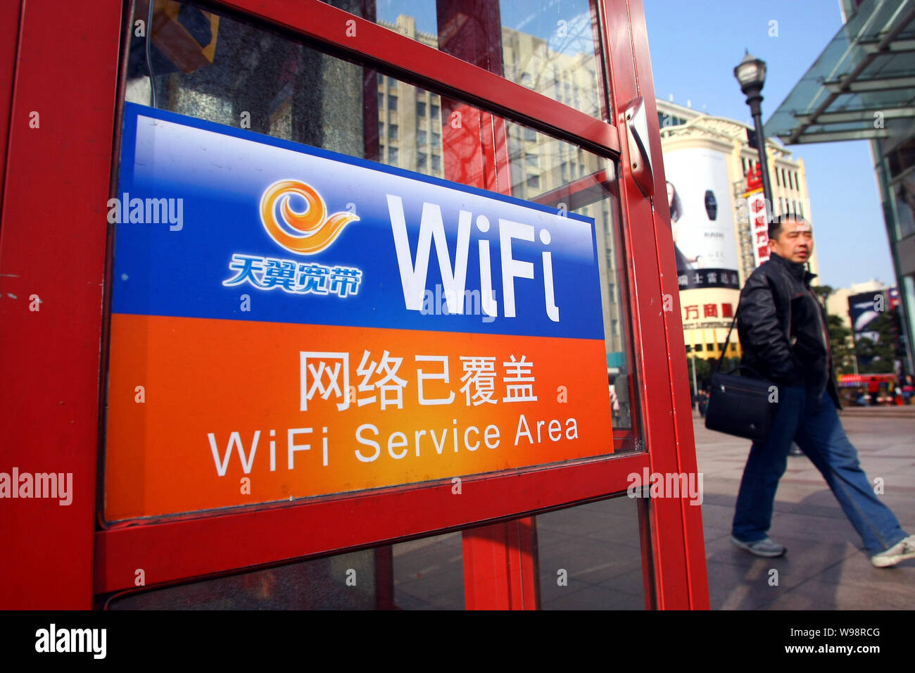 Ein chinesischer Mann vorbei an einer Telefonzelle von China Telecom bietet Wlan Dienstleistungen in der Innenstadt von Shanghai, China, 24. Februar 2011. Insgesamt 500 Pub Stockfoto