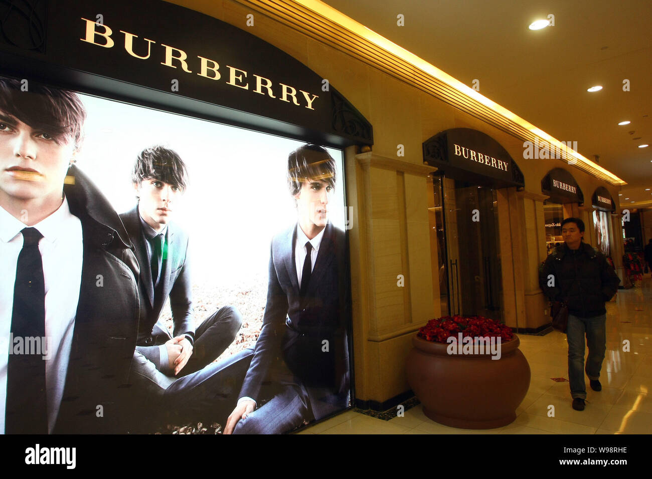 ---- Ein Fußgänger geht hinter einem Burberry Store in Shanghai, China, 21. Januar 2011. Der britischen Luxusmarke Burberry hat kürzlich unter Druck Stockfoto