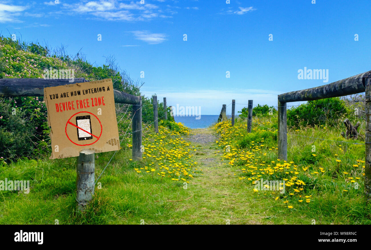 Gerät freie Zone Schild auf Post mit Weg zum Strand und Meer, Familie Spaß und Kleben in einem digitalen Free Zone Konzept Abbildung Stockfoto