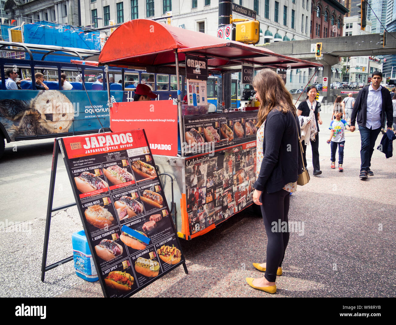 Ein Mädchen sieht das Menü eines Japadog hot dog Trailer stehen auf West Cordova Street in Vancouver, British Columbia, Kanada. Stockfoto
