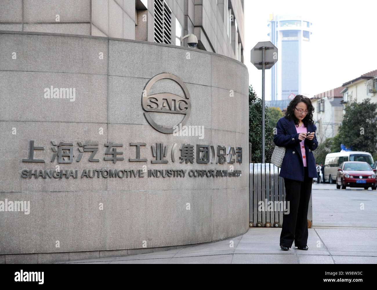 Eine chinesische Frau steht am Tor der Hauptsitz der SAIC (Shanghai Automotive Industry Corporation (Gruppe)) in Shanghai, China, 22. Februar 2011 Stockfoto