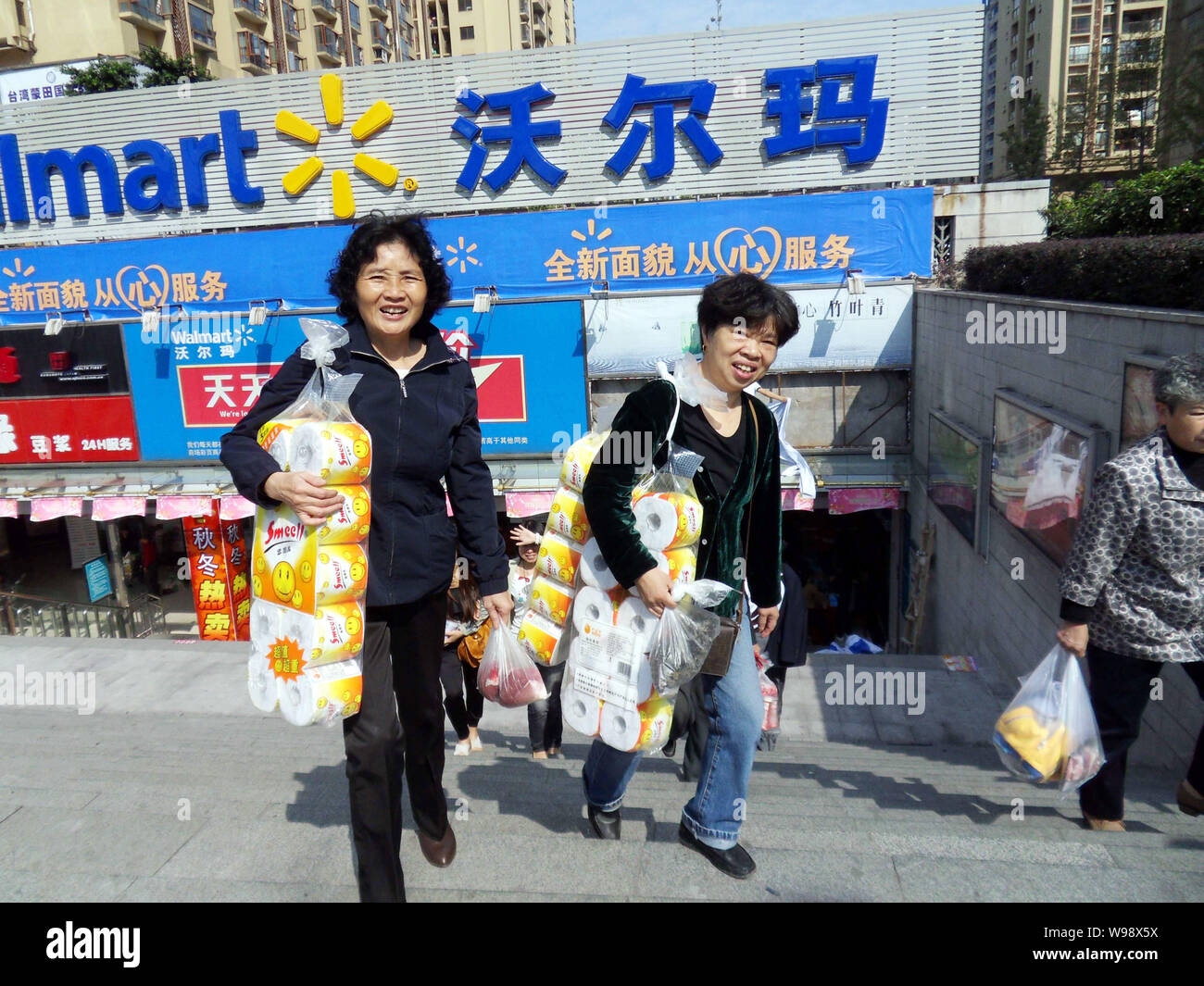 Chinesische Kunden gehen aus einem Wal-Mart Supermarkt, nachdem in einem Schwein vertrieb Sonde in Chongqing, China, 25. Oktober 2011 geschlossen, wieder geöffnet. Stockfoto