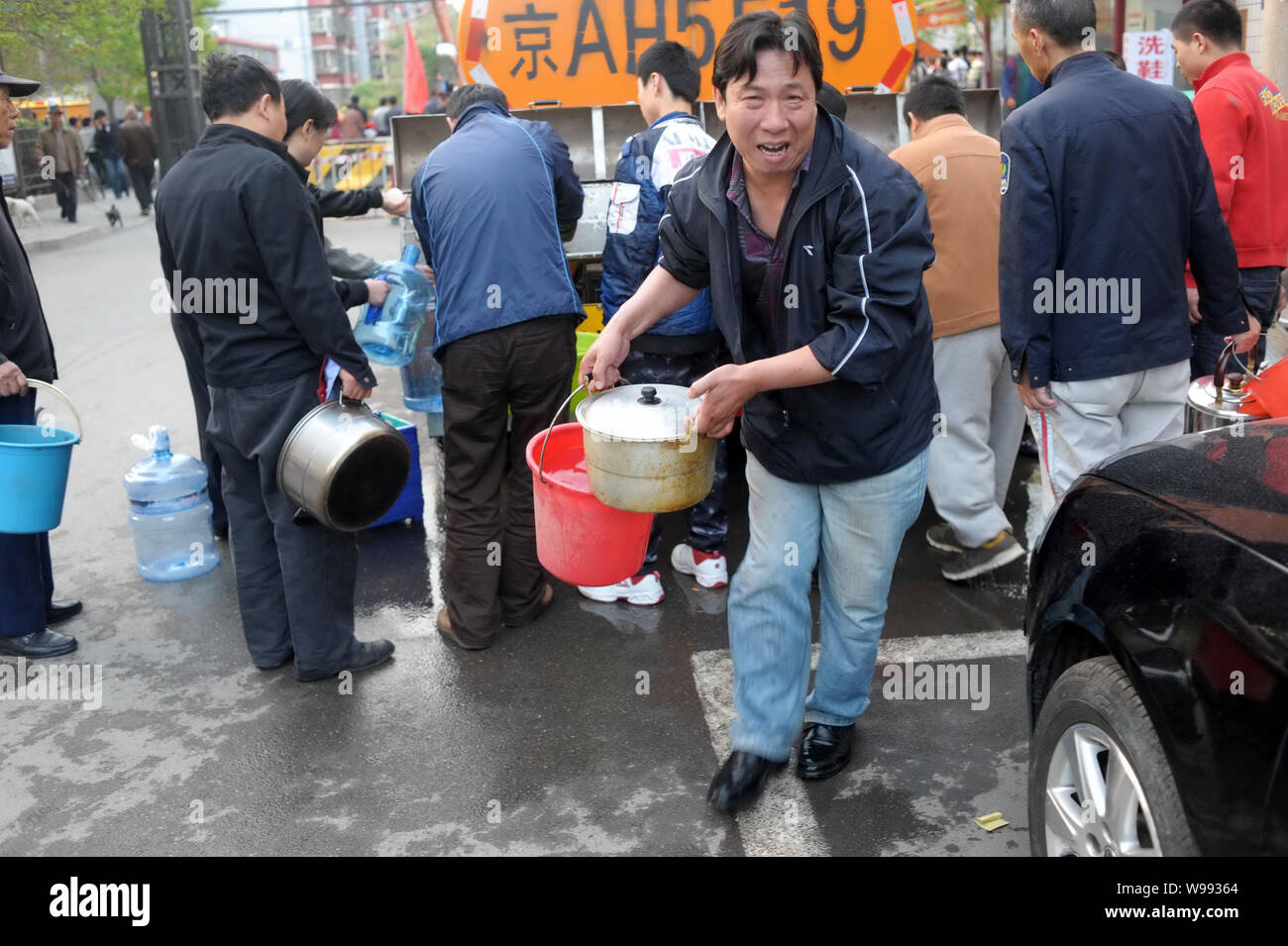 Anwohner füllen das Wasser durch die Wasserversorgung Fahrzeug mit ihren Haushalt an der Shi Liu Zhuang Road in Peking, China, 26. April 2011. O Stockfoto