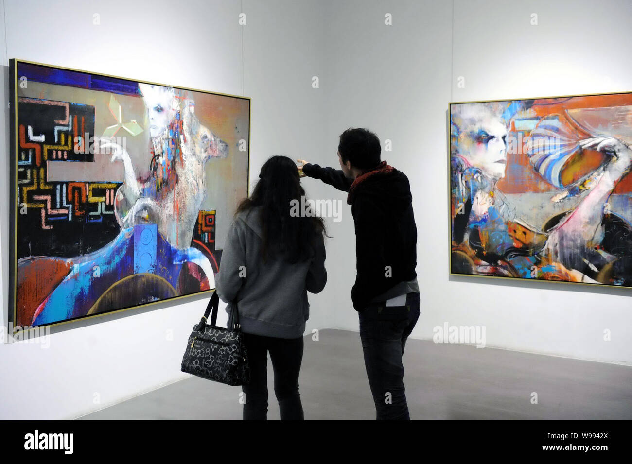 ---- Besucher Blick auf Gemälde in einer Galerie in Peking, China, November 6, 2010. Überholte China Großbritannien der weltweit zweitgrößte Kunst und eine Stockfoto