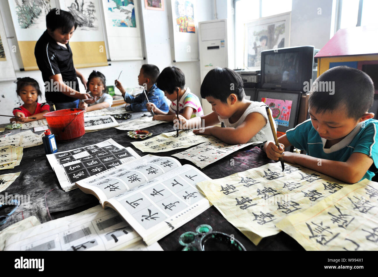 Die Schüler und Schülerinnen lernen, Kalligraphie in einer Klasse in Zhouping, East China Provinz Shandong, 29. August 2011. Kalligraphie, traditionelle Art und Weise der Aufnahme, ist grad Stockfoto