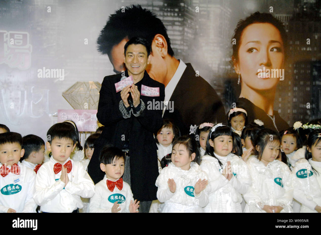 Hong Kong Sänger und Schauspieler Andy Lau stellt mit Kindern während der Premiere des Films, was Frauen wollen, in Hongkong, China, 13. Februar 2011. Stockfoto