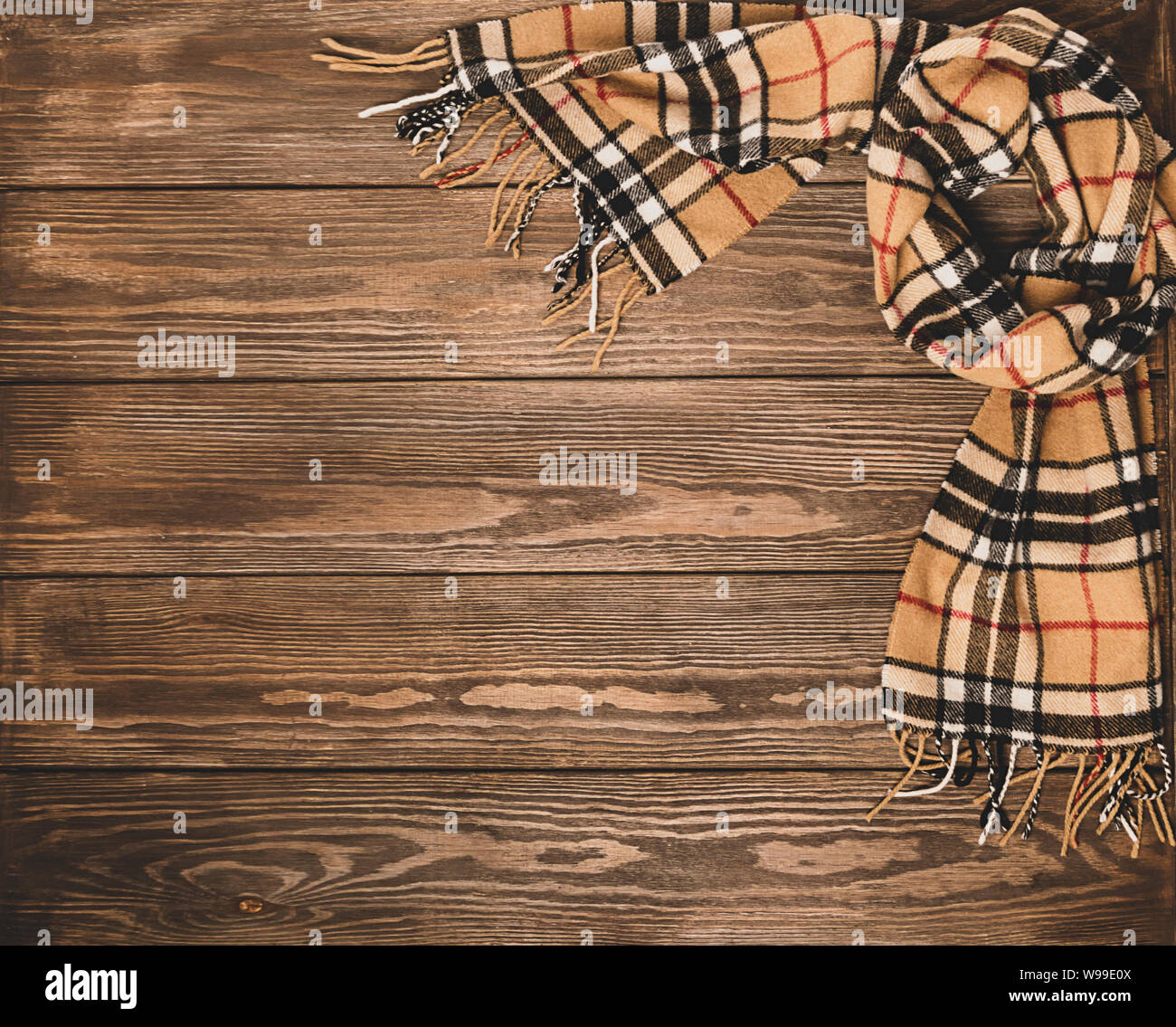 Wollschal mit Muster auf einer hölzernen braunen Hintergrund. Herbst Konzept. Für text Design statt. Flache layout Ansicht von oben. Stockfoto