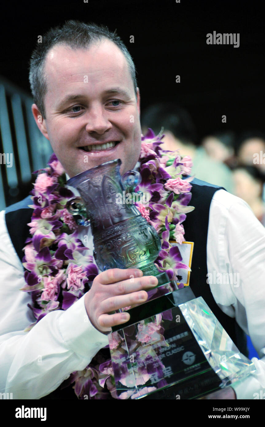 John Higgins von Schottland stellt seine Trophäe bei der Preisverleihung nach dem Finale der Internationalen Snooker Classic 2011 in Qionghai Stadt, Stockfoto