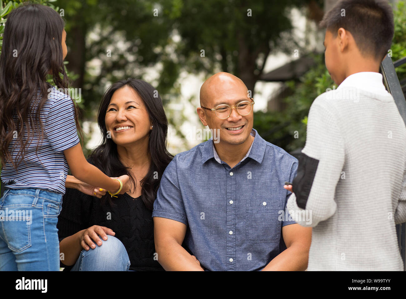 Porträt einer asiatischen Familie, die draußen lacht und spricht. Stockfoto
