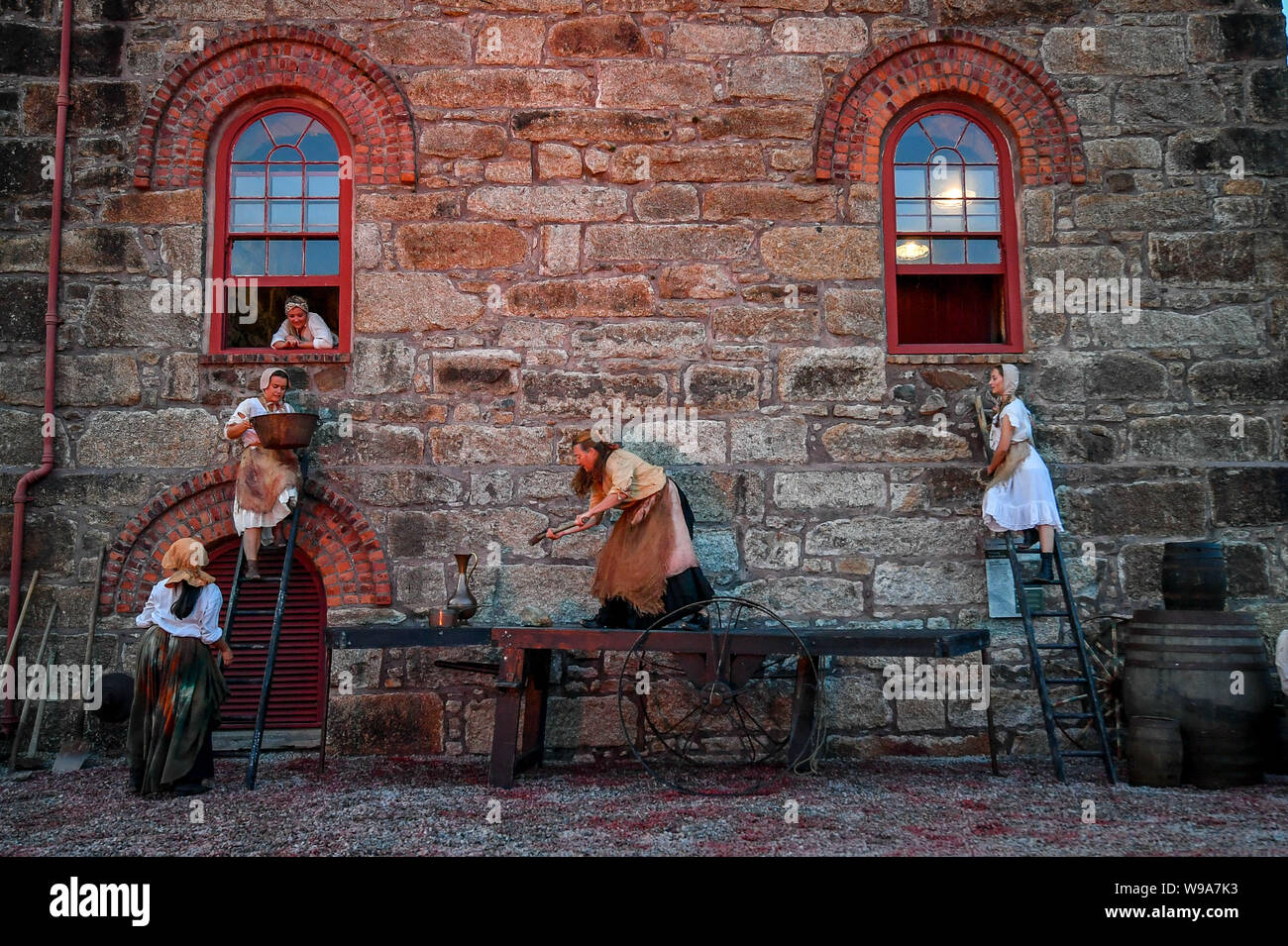 Darsteller Aufstieg bis zum Fenster während der Theatervorstellung der Estah???s Geschichte, die in der alten Grubenbaue im Herzland Weltkulturerbe, Cornwall eingestellt ist, mit Antenne Performances, Songs und gesprochenen Wortes, erzähle Geschichten aus der Cornish Bergbau in den 1800er Jahren. Stockfoto