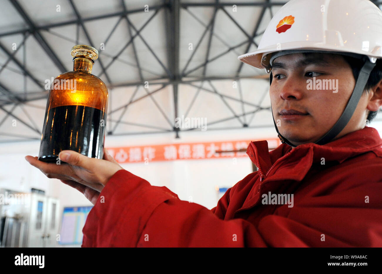 Ein chinesischer Arbeiter aus CNPC (China National Petroleum Corporation) zeigt eine Flasche von Rohöl aus der Ölleitung an der Klemme der China sampled-R Stockfoto