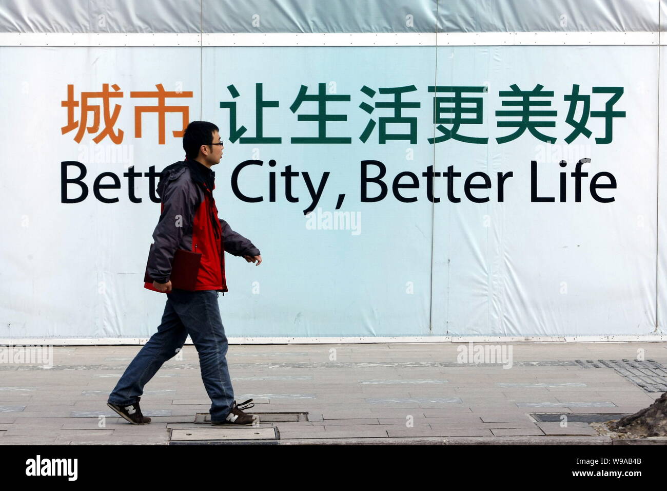 Ein chinesischer Mann Vergangenheit Anzeichen für Bessere Stadt, besseres Leben, ist das Thema der Weltausstellung Expo 2010 in Shanghai, China, 2. April 2010. Die Förderung song f Stockfoto