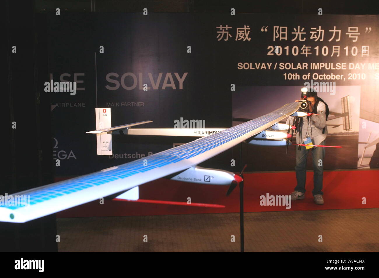 Ein Besucher nimmt Fotos eines Modells der Solar Impulse HB-SIA, das erste Flugzeug, das ausschließlich mit Solarenergie am Pavil Belgian-European Stockfoto