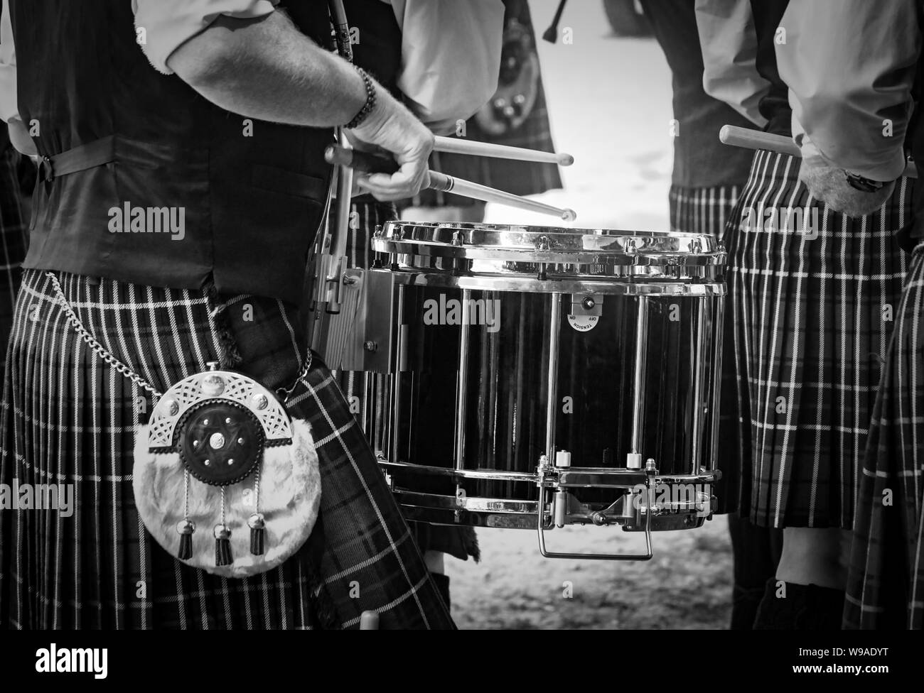Detailansicht der traditionellen schottischen Drum und die Hände von einem Schlagzeuger tragen kilt in Schottische Band spielen im Freien. Stockfoto