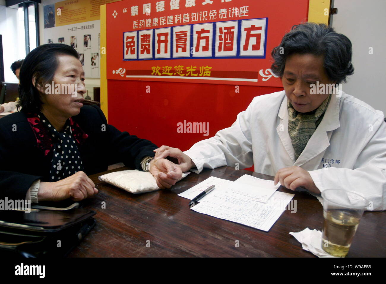 ---- Ein chinesischer Arzt aus der Traditionellen Chinesischen Medizin (TCM) Apotheke Diagnosen Krankheit für einen Patienten in Shanghai, China, 11. November 2009. Stockfoto