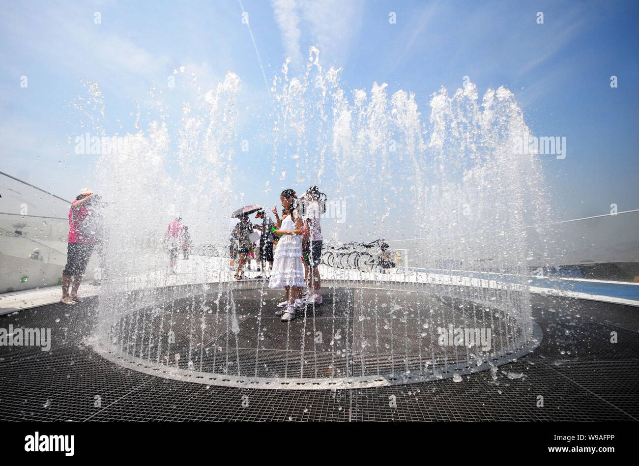 Besucher cool, sich in einen Brunnen auf dem Dach der Dänemark Pavillon auf der Weltausstellung in Shanghai, China, 21. Juli 2010. Stockfoto Besucher cool, sich in einen Brunnen auf dem Dach der Dänemark Pavillon auf der Weltausstellung in Shanghai, China, 21. Juli 2010. Stockfoto