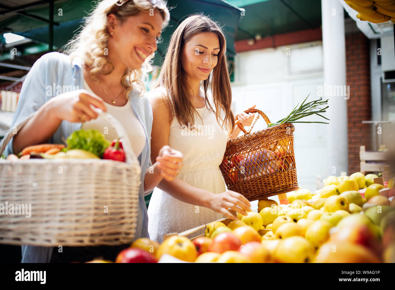 Junge Frauen, die gerne Einkaufen Gemüse und Früchte auf dem Markt Stockfoto