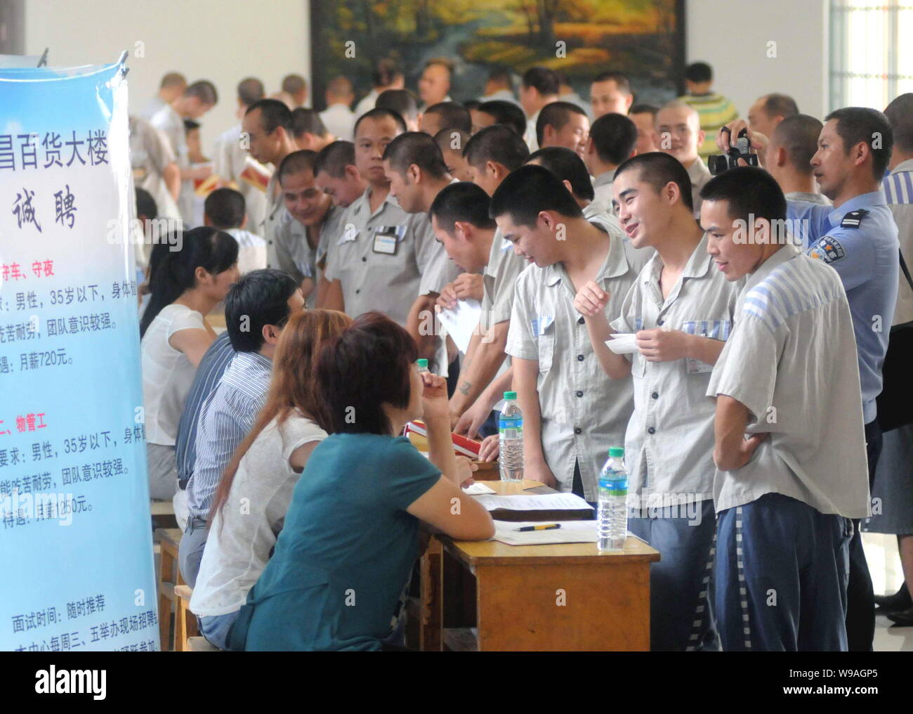 Chinesischen männlichen Insassen, die ihre Haftstrafe vollständig drängen einige Stände der compaines während einer Jobmesse in einem Gefängnis in Nanchang, China Stockfoto