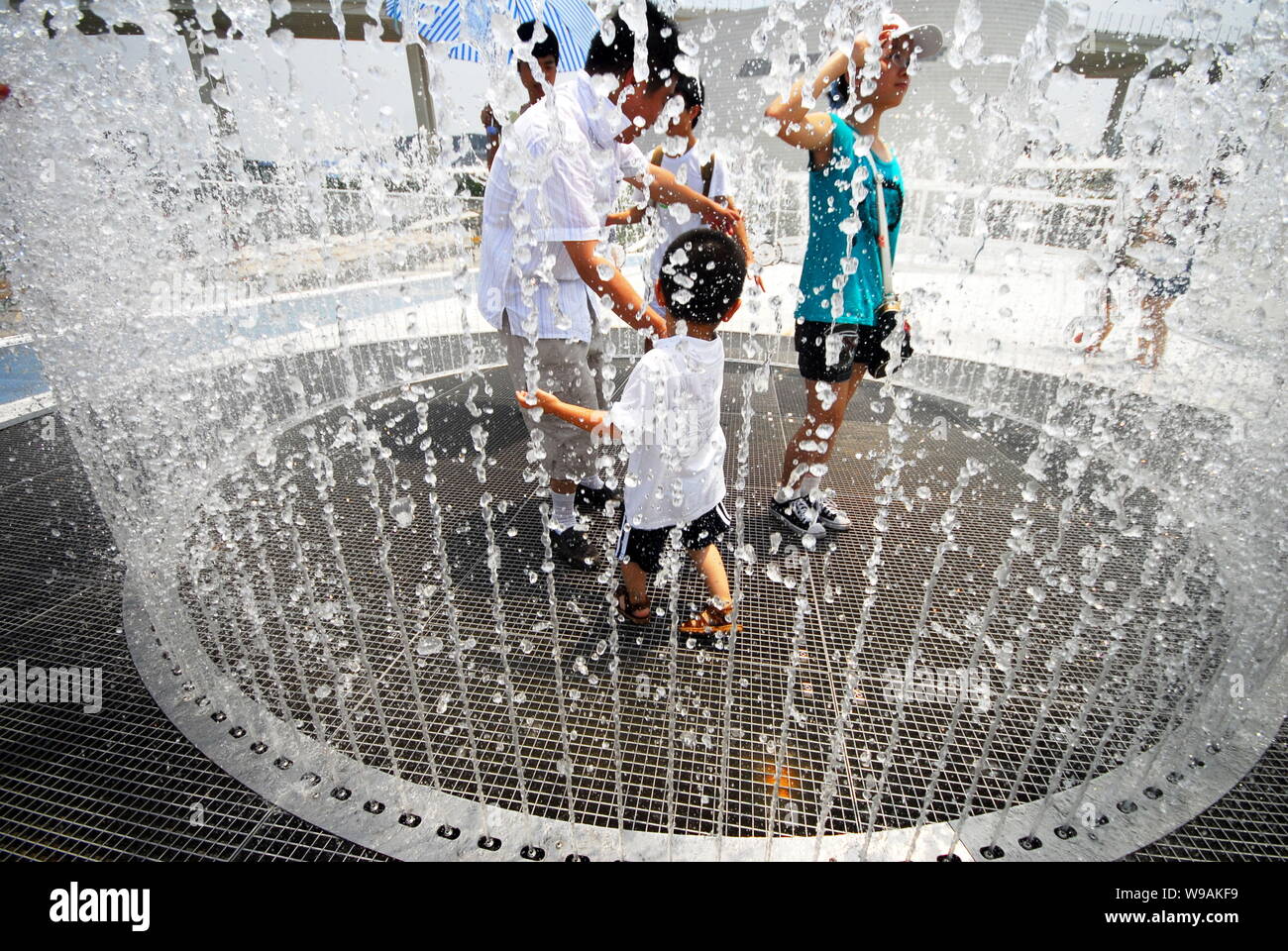 Besucher cool, sich in einen Brunnen auf dem Dach der Dänemark Pavillon auf der Weltausstellung in Shanghai, China, 21. Juli 2010. Stockfoto Besucher cool, sich in einen Brunnen auf dem Dach der Dänemark Pavillon auf der Weltausstellung in Shanghai, China, 21. Juli 2010. Stockfoto