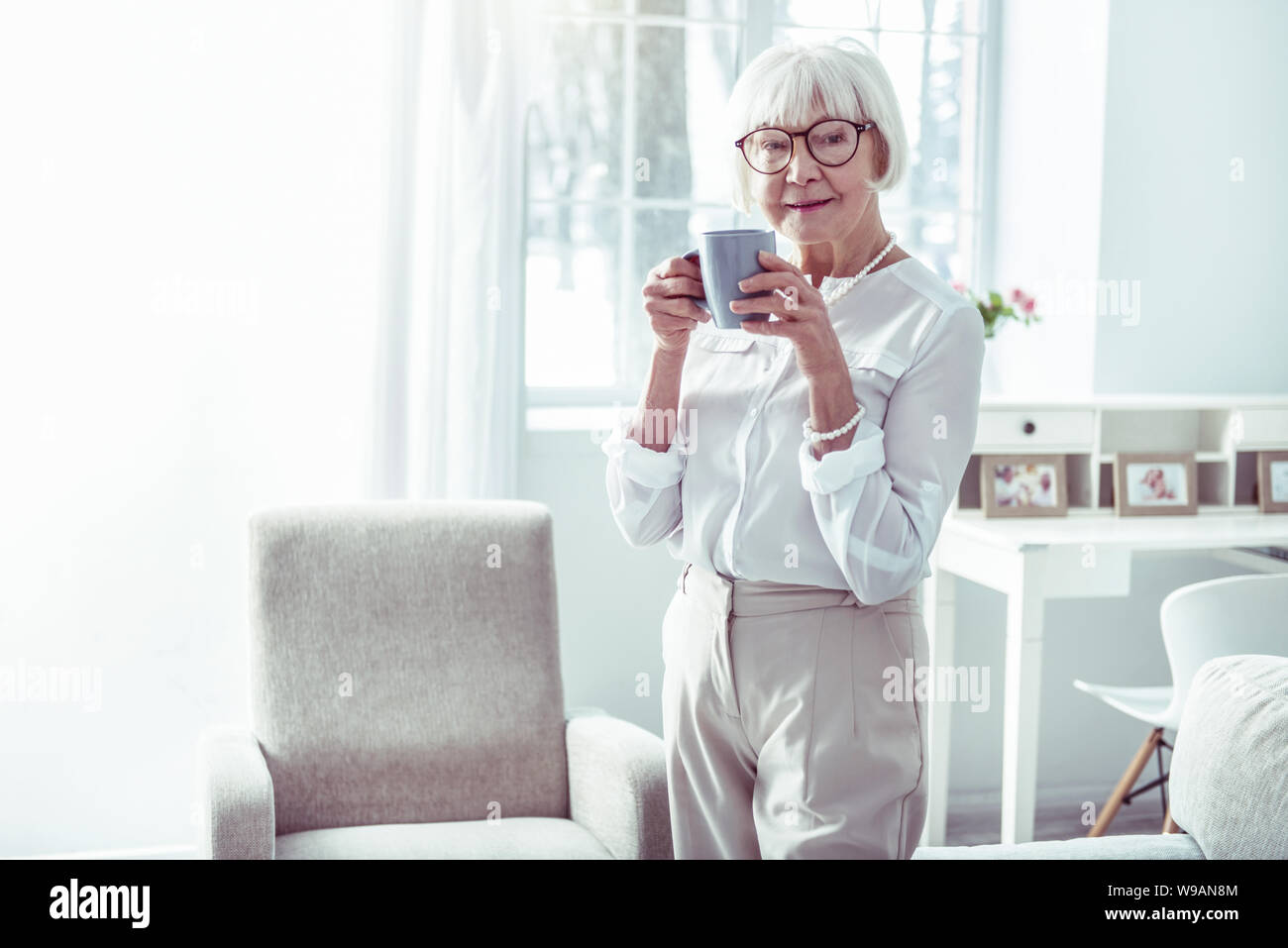 Elegante Dame Business Kleidung tragen, stehen in der Nähe der Fenster Stockfoto