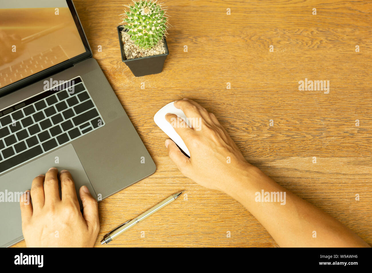 Business Mann hand mit Laptop und Maus mit Stift auf Holzschreibtisch. Stockfoto