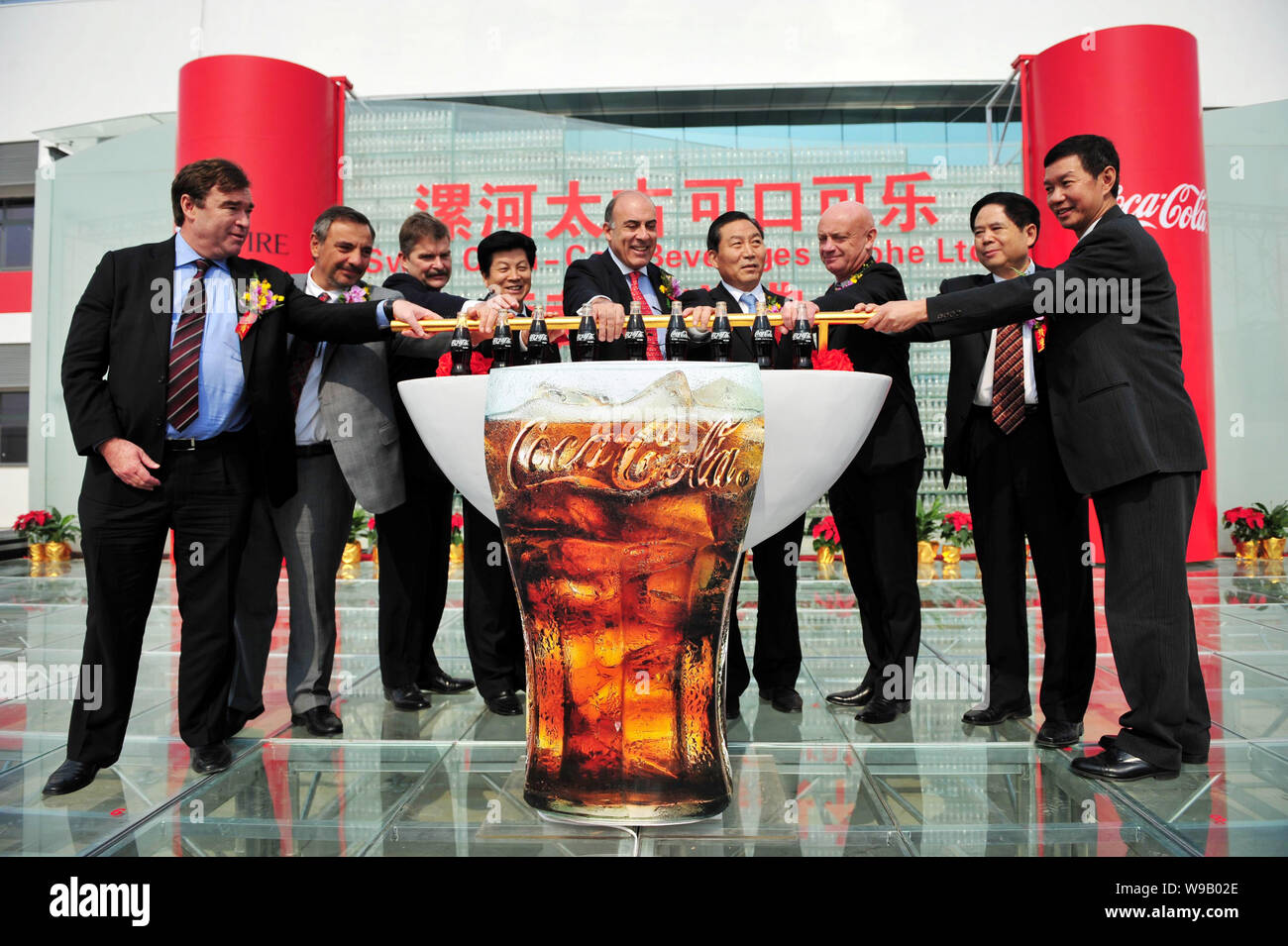 Muhtar Kent, Mitte, Vorsitzender und CEO von The Coca-Cola Company, Clive Saffery, Dritte rechts, CEO von China Operationen der Swire Beverages Ltd., und andere Stockfoto