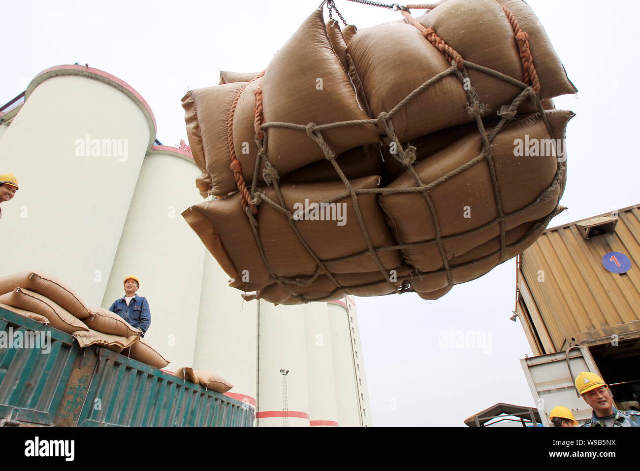 Chinesische Arbeiter laden ein Lkw mit Taschen für eingeführte Sojabohnen im Hafen von Nantong in Nantong City, East China Jiangsu Provinz, 14. Mai 2010. China Stockfoto