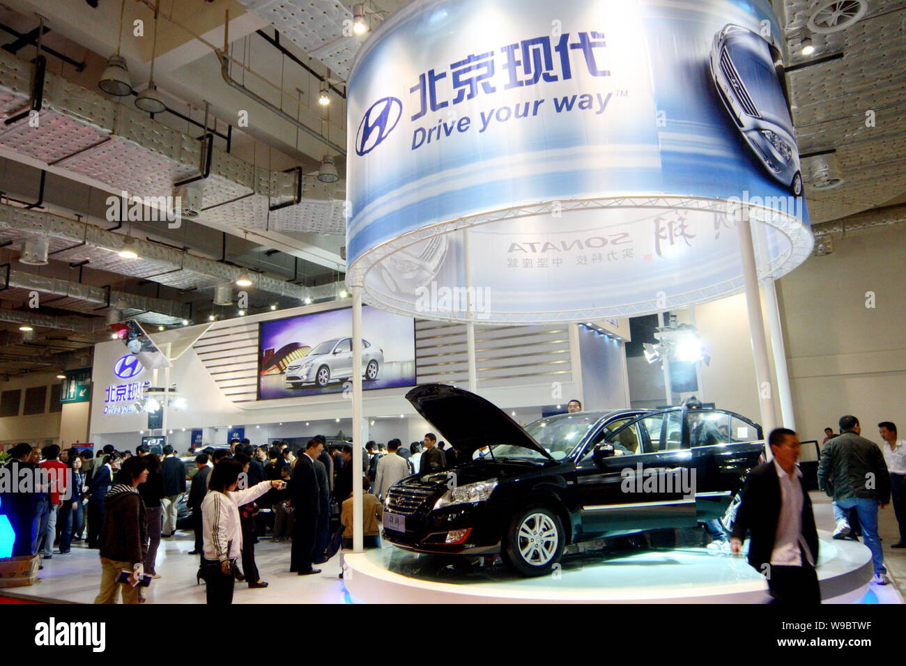 ------ Chinesischer Besucher Blick auf Autos von Beijing Hyundai, das Joint Venture zwischen Hyundai und Beijing Automotive Industry Holding Corp. (BAIC), duri Stockfoto