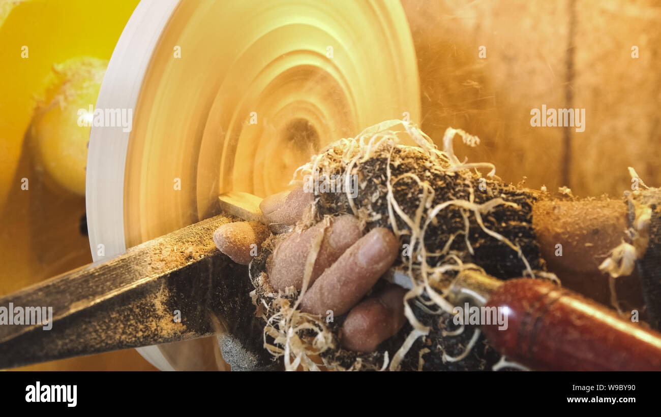 Tischler griffe Holz durch die Maschine. Builder arbeitet mit Werkstück im Arbeitsbereich. Die schöne hölzerne handgefertigte Platte. Herstellung von Holz- grabenbagger. W Stockfoto