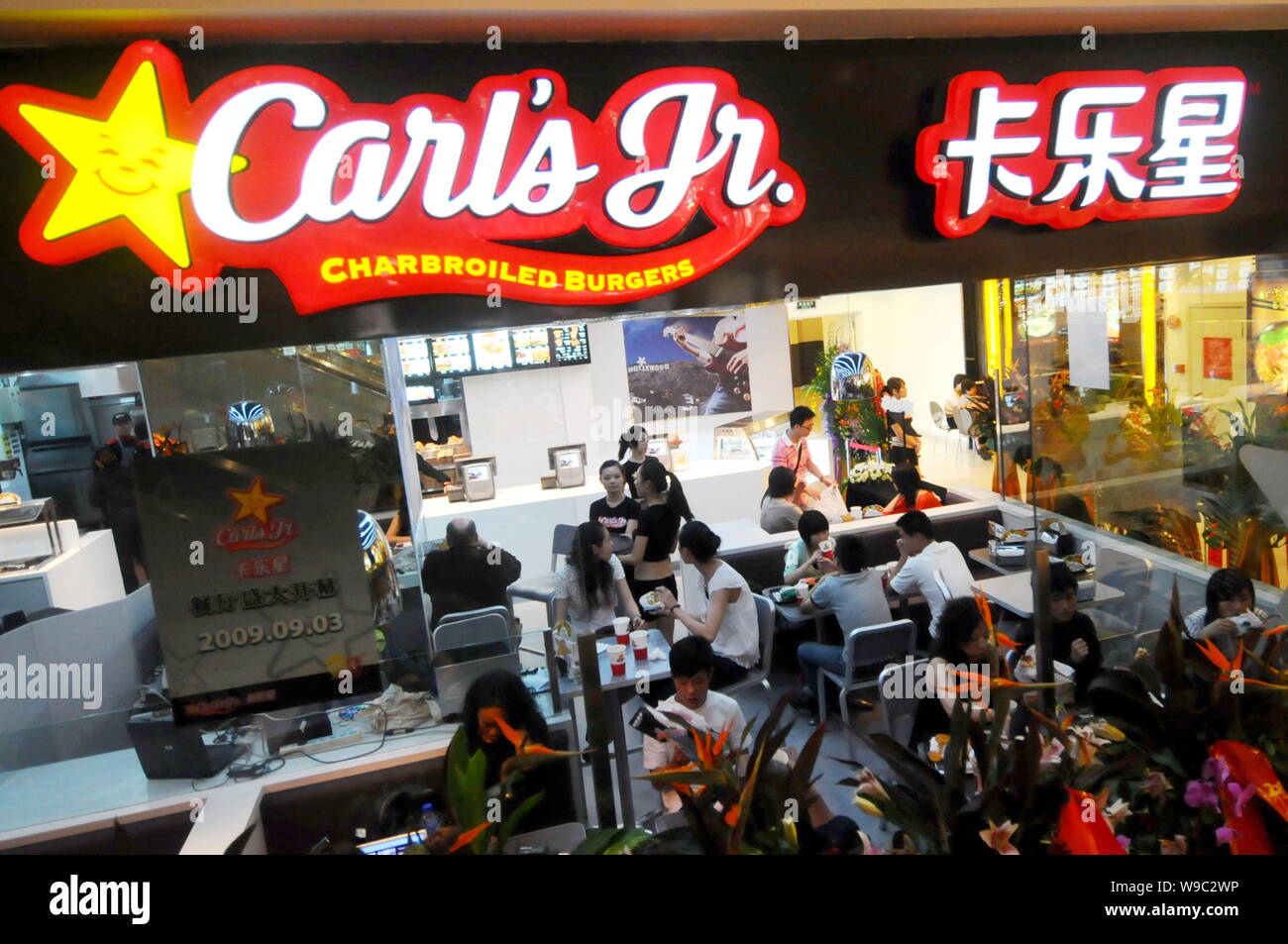 Kunden essen Essen zu einem Carls jr. Restaurant im Raffles City Mall in Shanghai, China, Mittwoch, 2. September 2009. Us-burger Marke Carls jr en Stockfoto