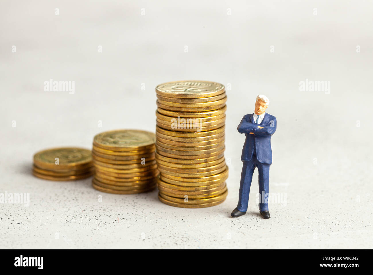 Erfolgreiche Unternehmer mit großen Gewinn am oberen Ende der Treppe durch Münzen. Angemessene Investitionen in das Unternehmen Stockfoto