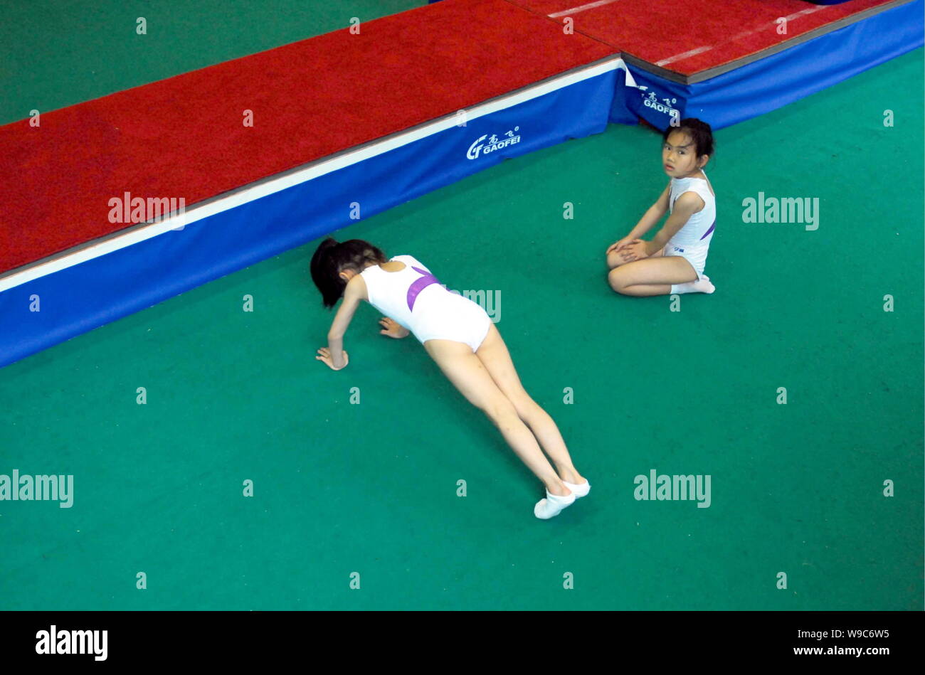 Ein kleiner chinesischer Trampolin Athleten Übung während einer Trainingseinheit auf der Fuzhou Ausbildung Basis für die Nationalen Trampolin Montage Ausbildung Team i Stockfoto