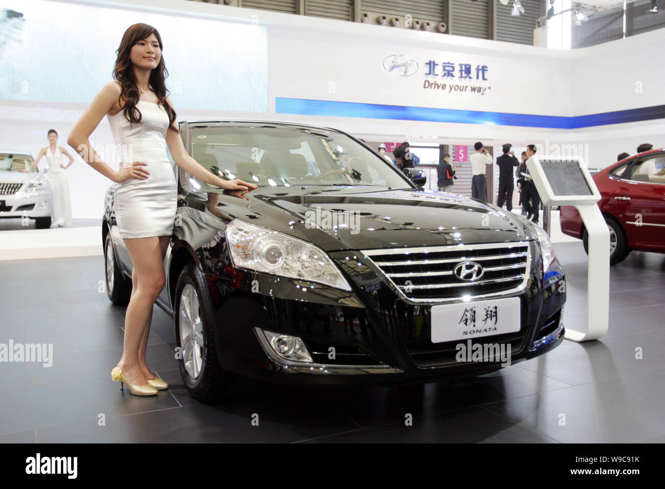 ---- Ein Modell wirft mit einer Sonate von Beijing Hyundai, das Joint Venture zwischen Hyundai und Beijing Automotive Industry Holding Corp. (BAIC), Stockfoto