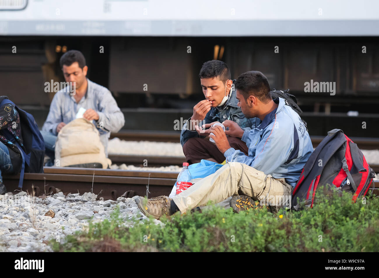 Dugo Selo, Kroatien - 17. September 2015: syrische Flüchtlinge sitzen auf den Gleisen und Essen nach der Ankunft aus Serbien und warten auf die Busse Stockfoto