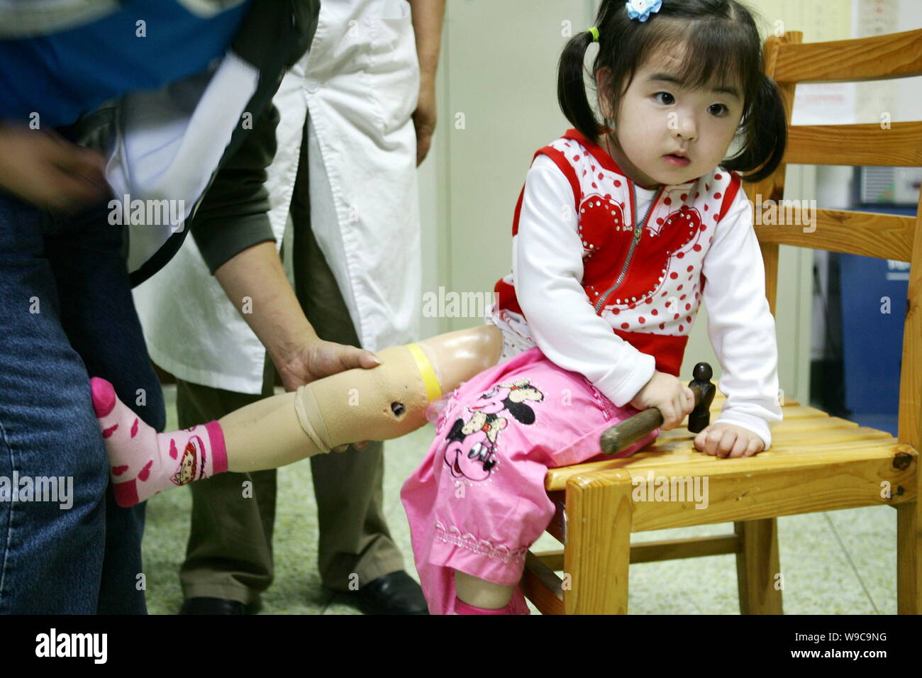 ---- Ein chinesischer Arzt prüft das künstliche Bein der Song Xinyi, 4 Jahre alt, die sie ihr rechtes Bein in der Mai 12 Erdbeben verloren, während eine rehabilitati Stockfoto
