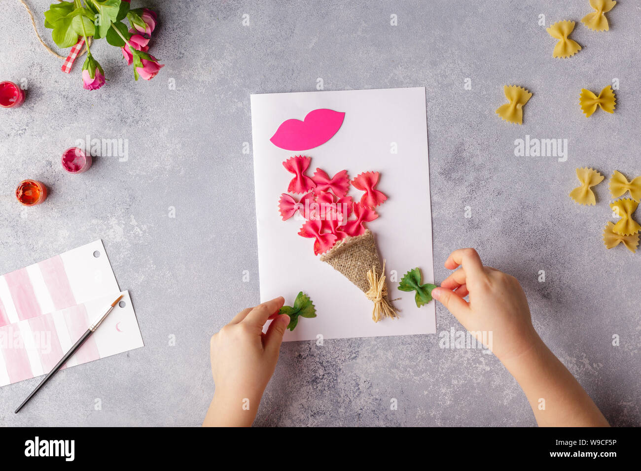 Papier basteln für Muttertag, 8. März oder Geburtstag. Kleines Kind tun  einen Blumenstrauß aus farbigem Papier und bunte Nudeln Stockfotografie -  Alamy