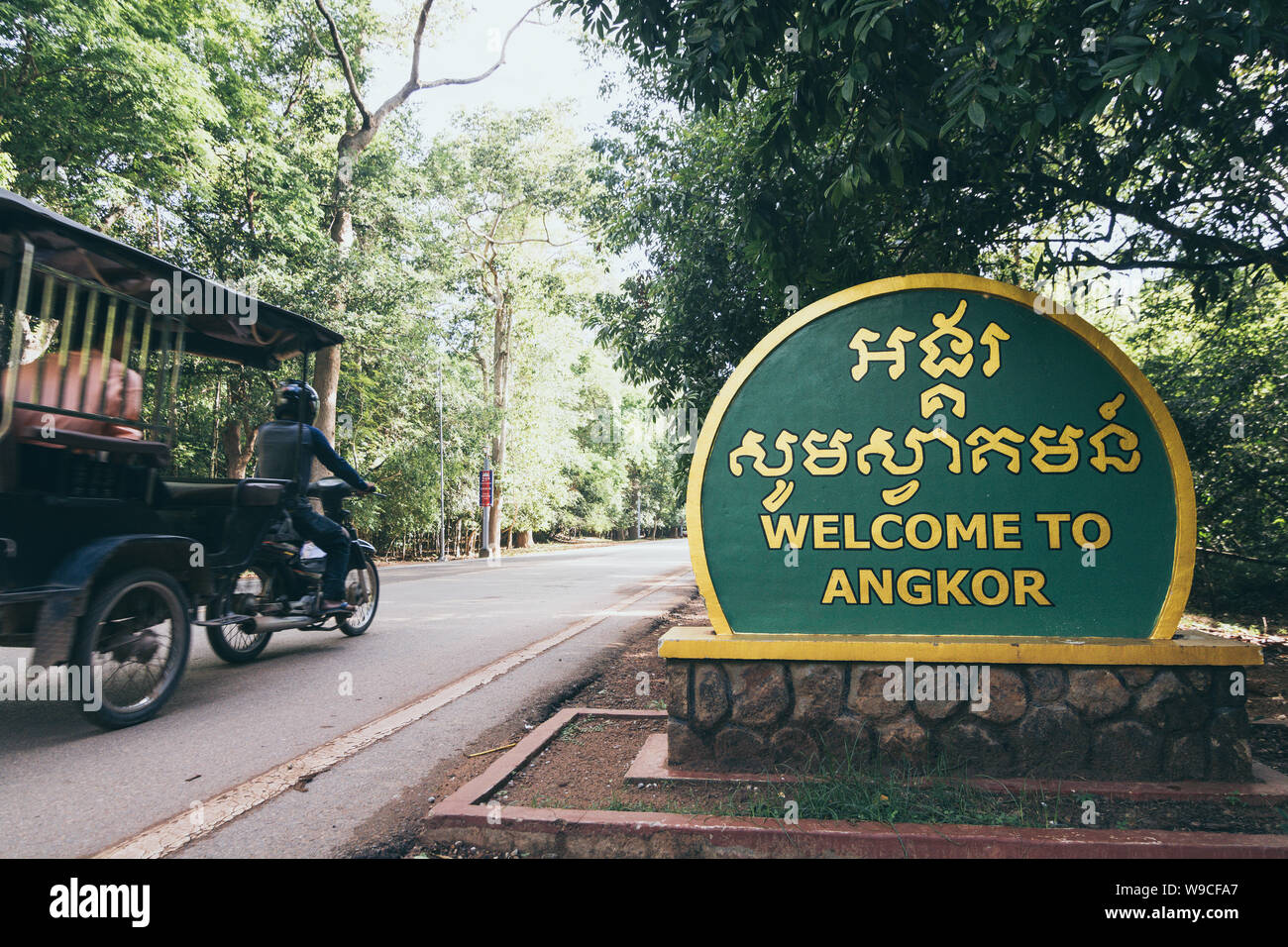 Siem Reap, Kambodscha - Juni 2019: Motorrad Rikscha fahren zu Angkor Wat Tempel vorbei Willkommen anmelden. Stockfoto