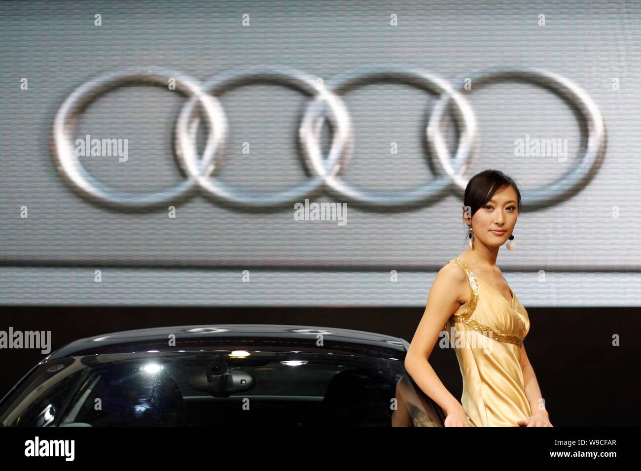 Ein Modell stellt mit einem Audi Auto während eines Auto Show in Peking, China, 24. Juli 2009. Deutsche Autobauer Audi, der von der Volkswagen AG gehört, plant, Stockfoto
