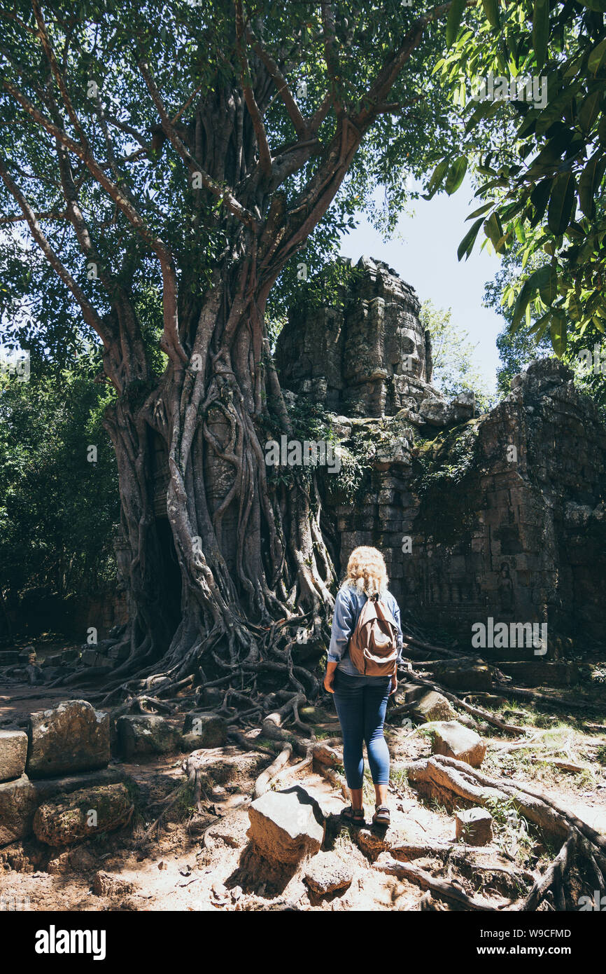 Kaukasische blonde Frau, die Entdeckung der Ruinen von Angkor Wat Tempel Komplex in Siem Reap, Kambodscha. Baum auf dem Dach des Tempels Eingangstor arc Stockfoto